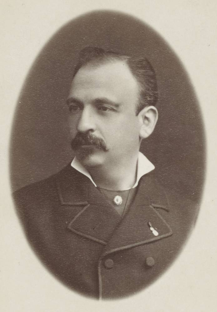 Photographie ancienne, en noir et blanc, montrant le portrait en buste d’un homme.