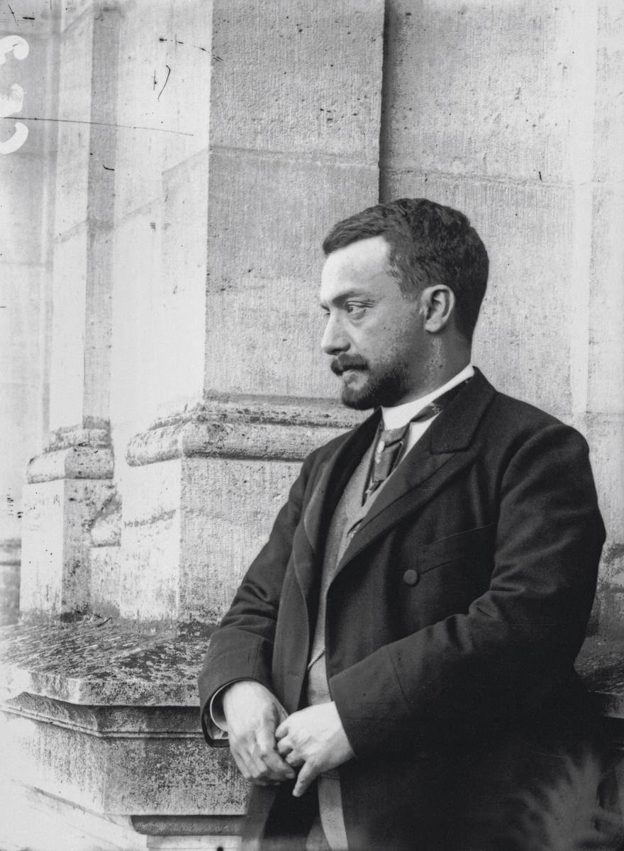 Photographie ancienne, en noir et blanc, montrant le portrait à mi-corps d’un homme de profil.