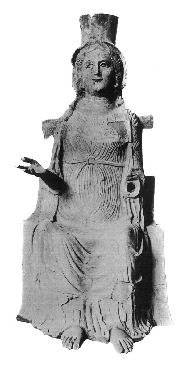 Photographie ancienne, en noir et blanc, représentant une statuette de personnage féminin assis.